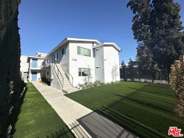 rear view of property featuring a lawn