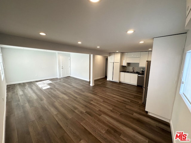 unfurnished living room featuring dark hardwood / wood-style flooring and sink