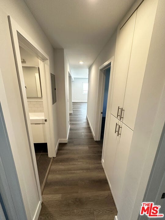 hall with dark wood-type flooring and electric panel