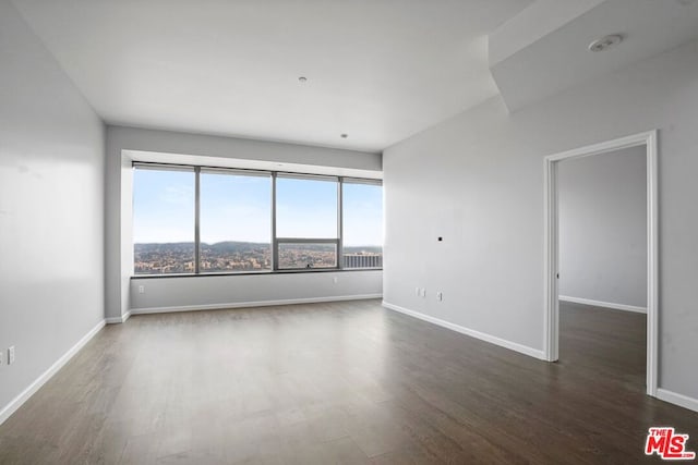 empty room with dark hardwood / wood-style flooring