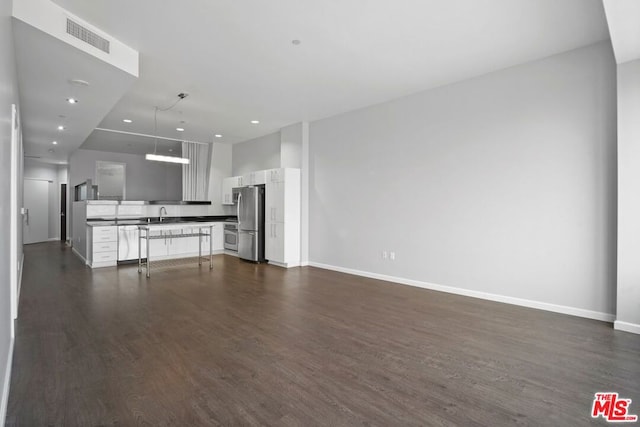 unfurnished living room with dark hardwood / wood-style flooring and sink