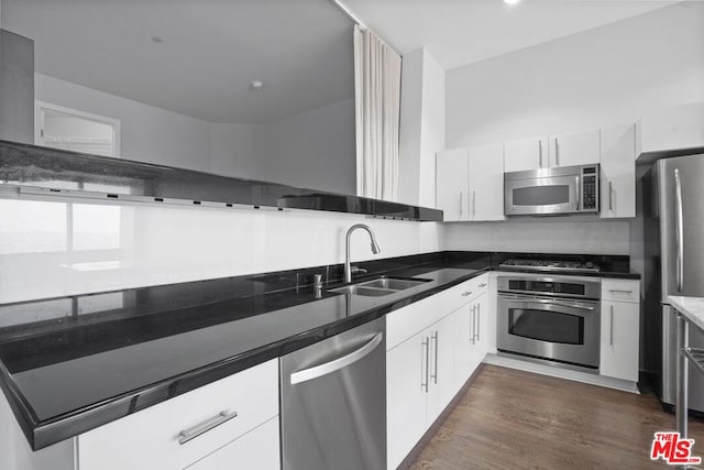 kitchen with dark hardwood / wood-style floors, white cabinetry, sink, and appliances with stainless steel finishes