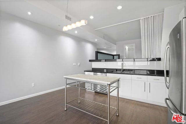 kitchen featuring pendant lighting, white cabinets, sink, dark hardwood / wood-style floors, and appliances with stainless steel finishes