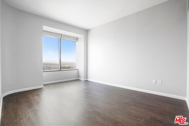 unfurnished room with dark hardwood / wood-style flooring