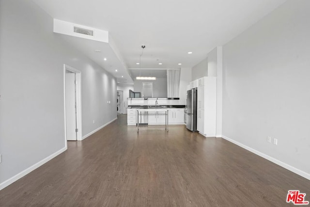 kitchen featuring white cabinetry, stainless steel refrigerator, dark wood-type flooring, and sink