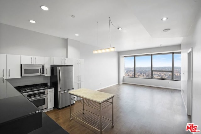 kitchen with white cabinets, appliances with stainless steel finishes, decorative light fixtures, and dark wood-type flooring