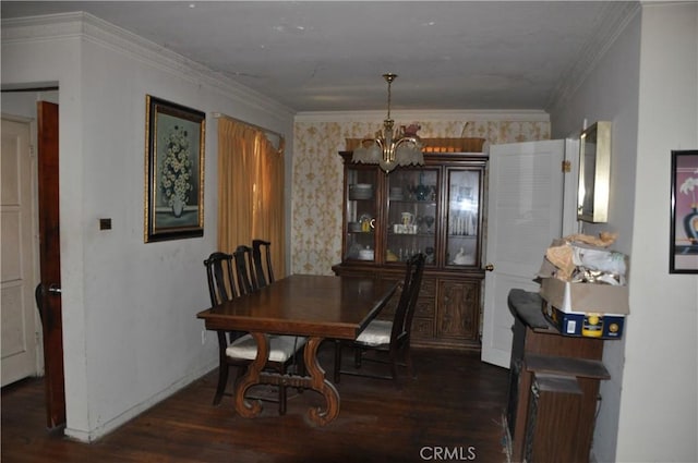 dining area with dark hardwood / wood-style floors, ornamental molding, and an inviting chandelier