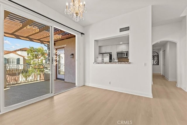 interior space featuring light hardwood / wood-style floors and an inviting chandelier