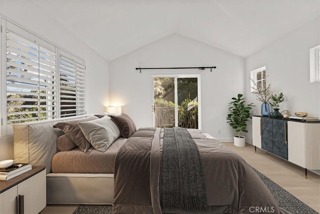 bedroom with multiple windows, vaulted ceiling, access to outside, and light wood-type flooring