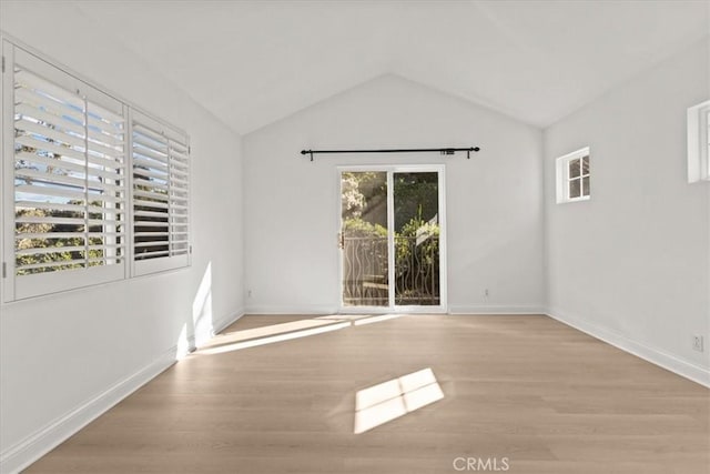 empty room featuring lofted ceiling and light wood-type flooring