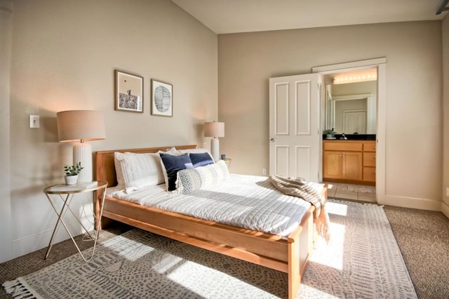 carpeted bedroom featuring ensuite bathroom and vaulted ceiling