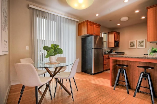 kitchen with stainless steel fridge and light hardwood / wood-style flooring