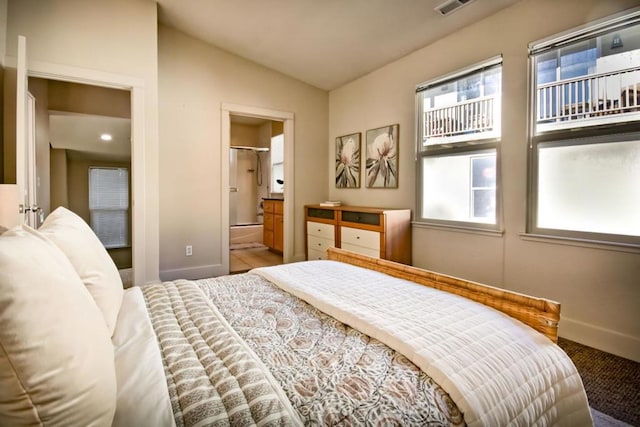 bedroom featuring lofted ceiling and ensuite bath