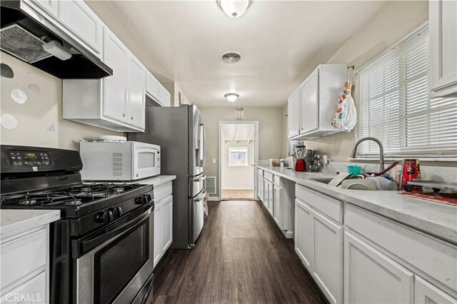 kitchen with a wealth of natural light, stainless steel appliances, white cabinets, and sink