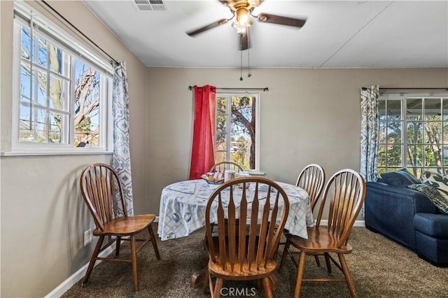 carpeted dining area with ceiling fan