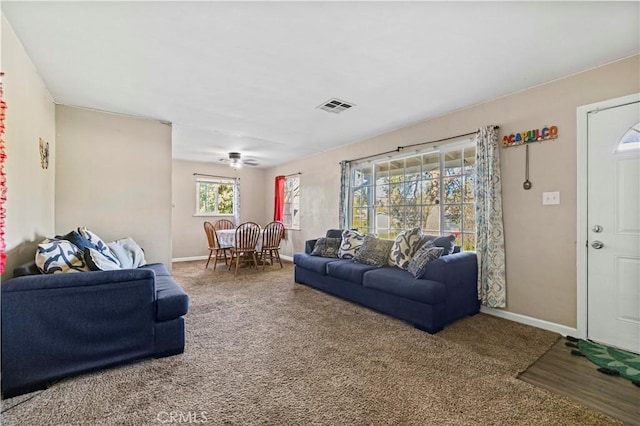 carpeted living room with ceiling fan