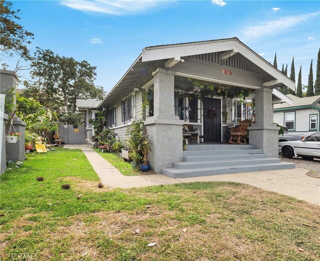 view of front facade featuring covered porch and a front yard