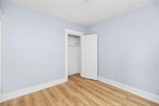 unfurnished bedroom with a closet and light hardwood / wood-style floors