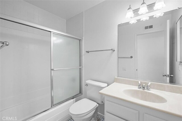 full bathroom with toilet, vanity, and bath / shower combo with glass door