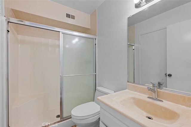 bathroom with toilet, a shower with shower door, and vanity