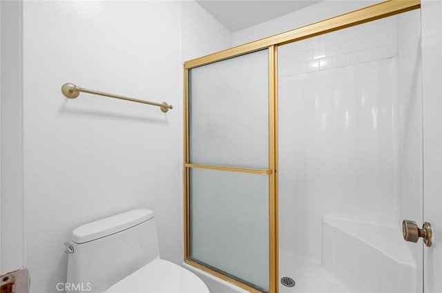 bathroom with toilet and a shower with door