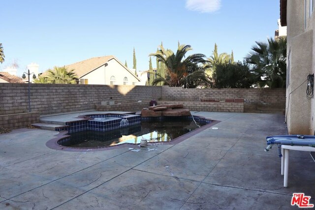 view of pool featuring a patio area and an in ground hot tub