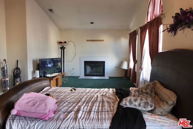 bedroom featuring a tiled fireplace