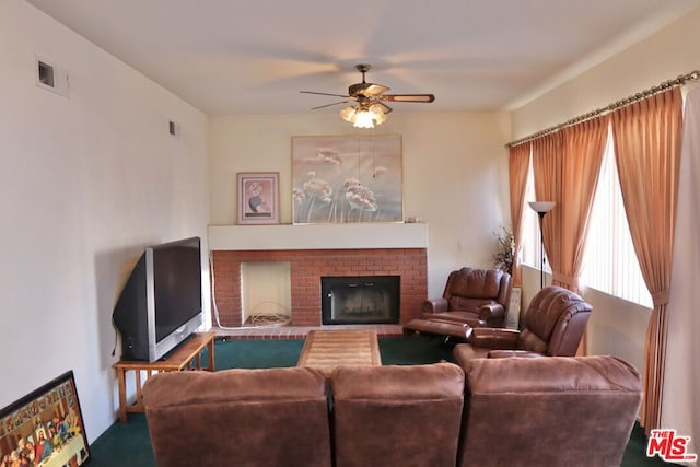 living room with ceiling fan and a fireplace