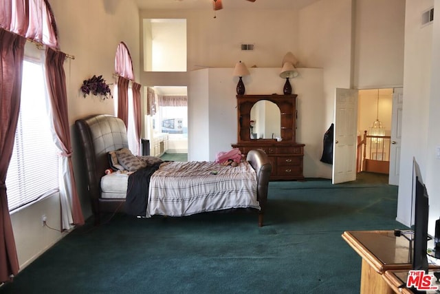 bedroom with dark carpet and a towering ceiling