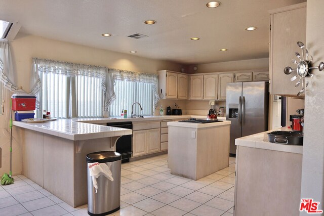 kitchen featuring a center island, black appliances, sink, tile countertops, and light tile patterned floors