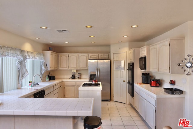 kitchen featuring black appliances, kitchen peninsula, tile countertops, and light tile patterned flooring