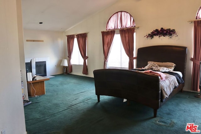 bedroom featuring carpet floors, vaulted ceiling, and a fireplace