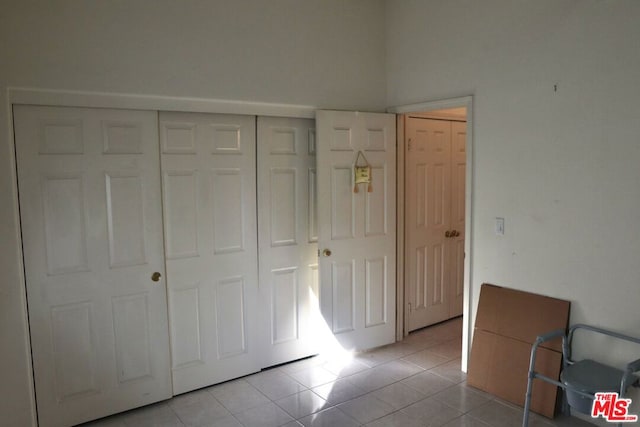 unfurnished bedroom featuring light tile patterned floors and a closet