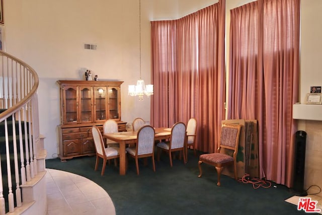 tiled dining area with a notable chandelier and a high ceiling