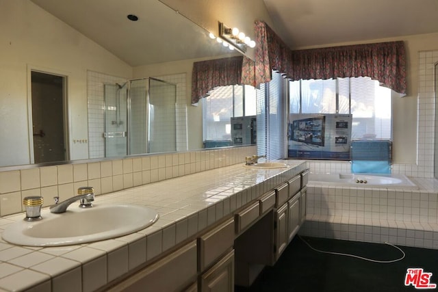 bathroom with decorative backsplash, vanity, lofted ceiling, and independent shower and bath