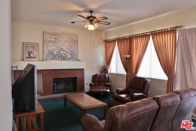 living room featuring ceiling fan and a brick fireplace