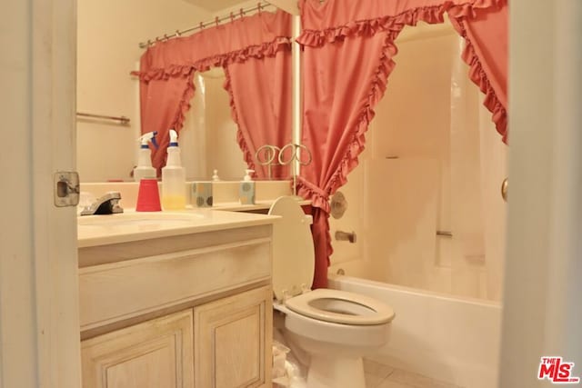 full bathroom with toilet, tile patterned floors, vanity, and shower / bath combo with shower curtain