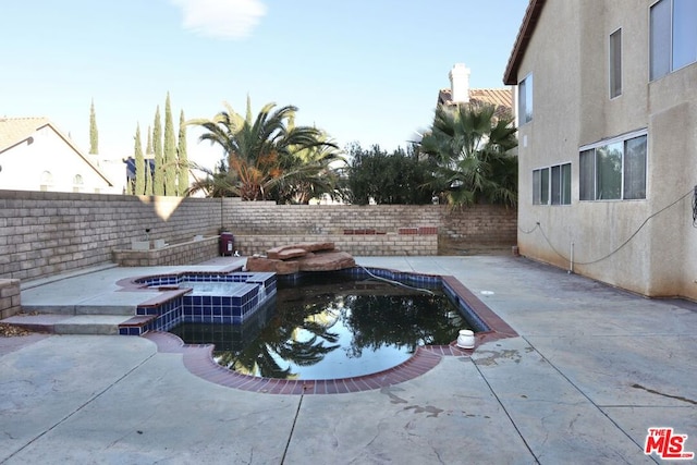 view of swimming pool featuring a patio and an in ground hot tub