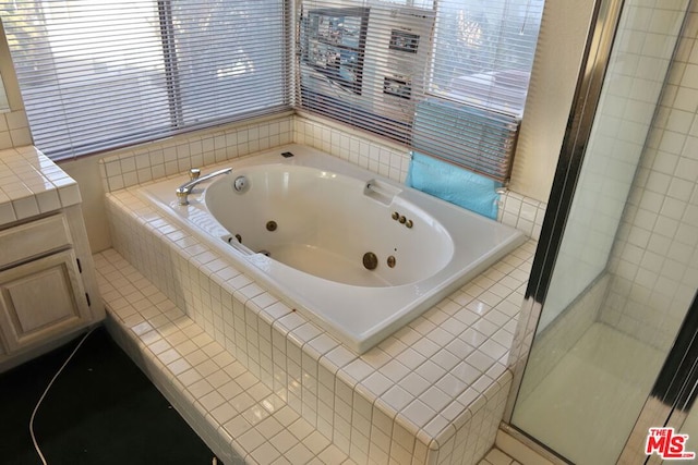 bathroom with tile patterned floors, separate shower and tub, and vanity