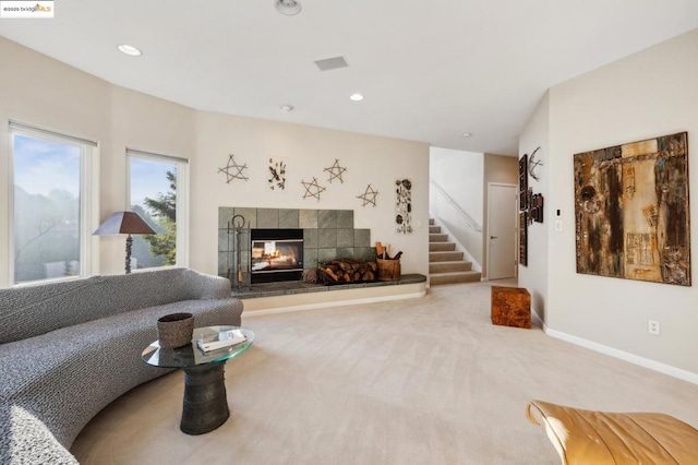 carpeted living room featuring a tiled fireplace