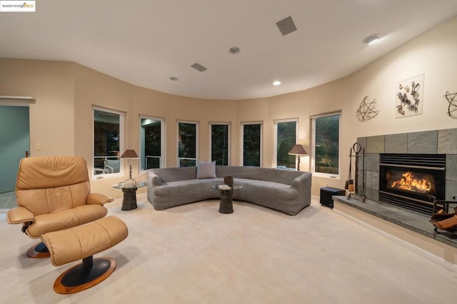 carpeted living room with a tiled fireplace