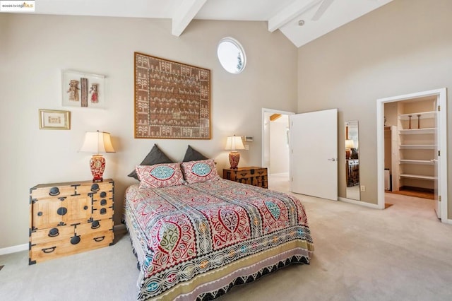 bedroom featuring carpet flooring, high vaulted ceiling, a closet, a walk in closet, and beam ceiling