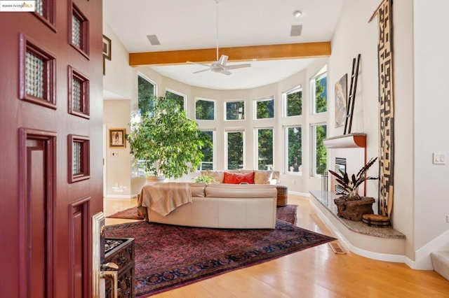 living room featuring hardwood / wood-style flooring, ceiling fan, and beamed ceiling