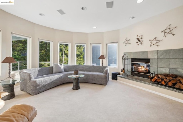 carpeted living room with a tile fireplace