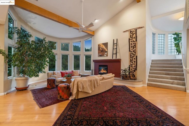 living room with high vaulted ceiling, wood-type flooring, ceiling fan, and beamed ceiling