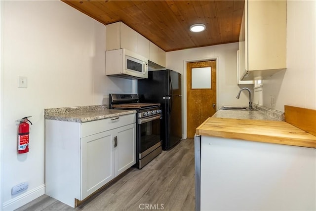 kitchen featuring white cabinets, stainless steel range oven, wood ceiling, light hardwood / wood-style floors, and sink