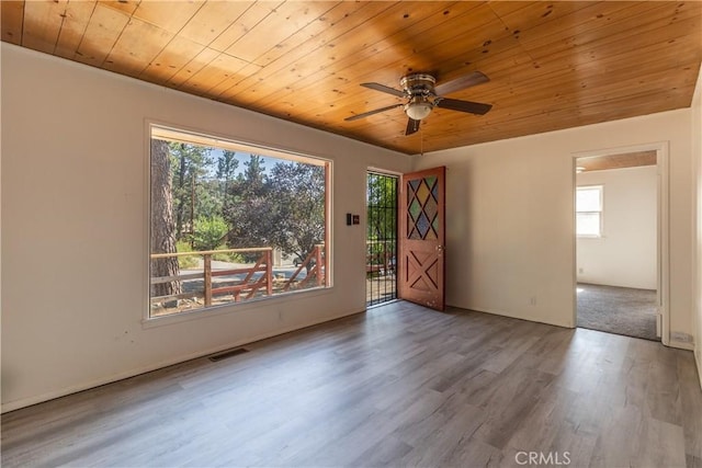 empty room with ceiling fan, wood ceiling, and wood-type flooring