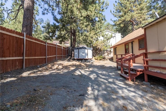 view of yard with a wooden deck and a storage unit