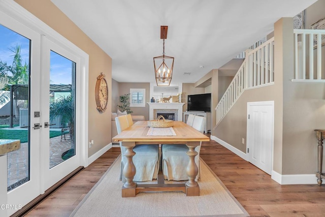 dining room featuring a notable chandelier, french doors, and light wood-type flooring