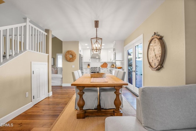 dining space with an inviting chandelier and light hardwood / wood-style floors